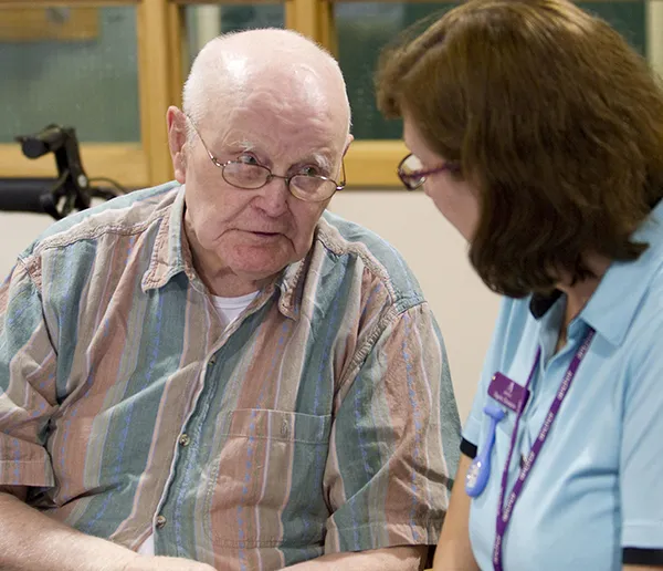Care home resident in conversation with a staff member during a CST session